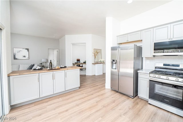 10301 Coal Creek Pl, Las Vegas, NV 89134 - kitchen featuring appliances with stainless steel finishes, light wood-type flooring, decorative backsplash, a peninsula, and recessed lighting