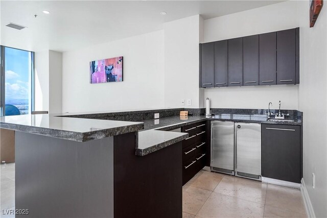 2700 S Las Vegas Blvd Unit 4305, Las Vegas, NV 89109 - kitchen with a peninsula, a sink, dark stone counters, and modern cabinets