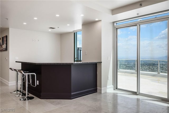 2700 S Las Vegas Blvd Unit 4305, Las Vegas, NV 89109 - kitchen featuring baseboards, recessed lighting, a kitchen bar, and dark stone counters