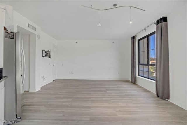unfurnished room featuring light wood-style flooring and baseboards