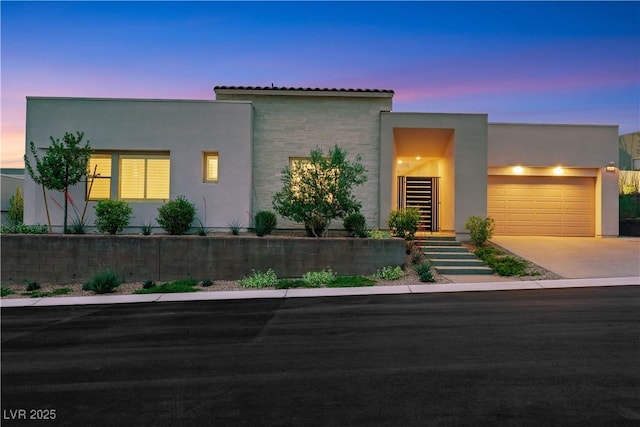 11895 Skyline Arch Ct, Las Vegas, NV 89138 - contemporary house featuring an attached garage, stucco siding, concrete driveway, and a tile roof