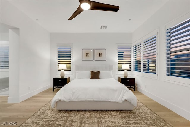 11895 Skyline Arch Ct, Las Vegas, NV 89138 - bedroom with light wood-type flooring, multiple windows, and baseboards