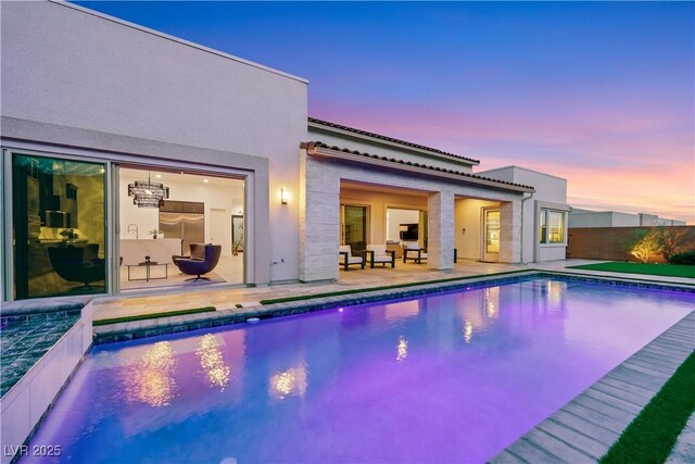 11895 Skyline Arch Ct, Las Vegas, NV 89138 - back of house at dusk featuring stucco siding, a patio area, fence, and a tile roof