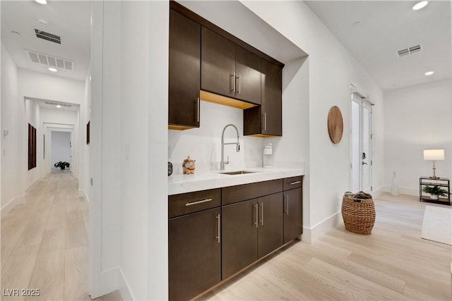 11895 Skyline Arch Ct, Las Vegas, NV 89138 - bar area with light wood-style floors, a sink, baseboards, and recessed lighting