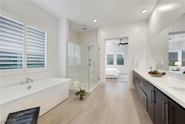 11895 Skyline Arch Ct, Las Vegas, NV 89138 - bathroom featuring a shower stall, a freestanding tub, wood finished floors, ceiling fan, and double vanity