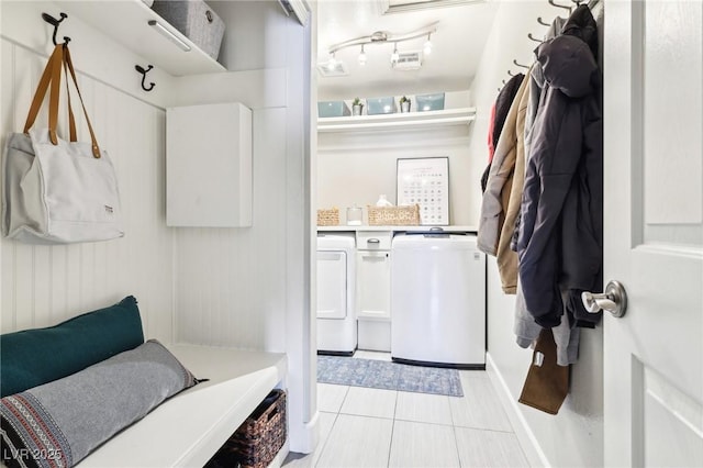 mudroom featuring separate washer and dryer, light tile patterned floors, and baseboards