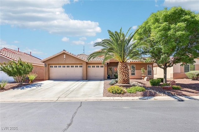view of front of property with an attached garage, stucco siding, and concrete driveway