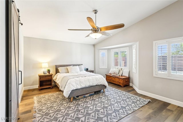 bedroom with multiple windows, lofted ceiling, wood finished floors, and baseboards