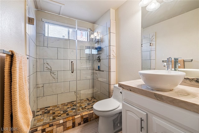 5449 Desert Spring Rd, Las Vegas, NV 89149 - bathroom with a stall shower, vanity, toilet, a textured wall, and wood finished floors