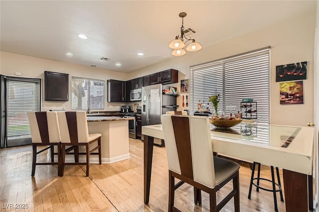 dining space with light wood finished floors and recessed lighting