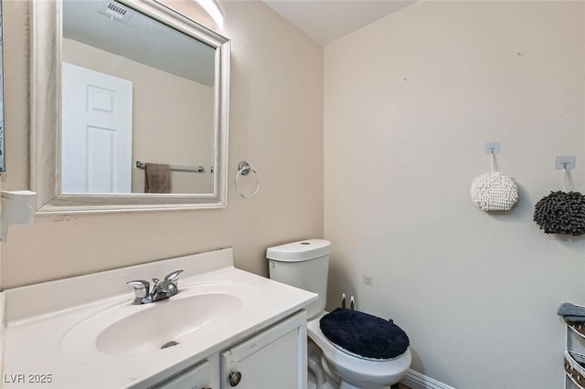 bathroom with vanity, toilet, and baseboards