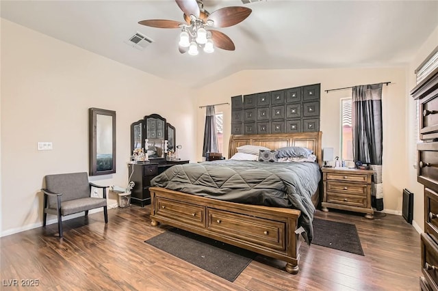 bedroom featuring lofted ceiling, dark wood finished floors, baseboards, and a ceiling fan