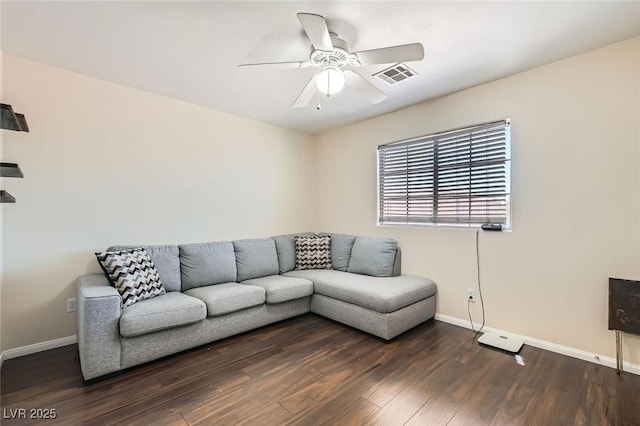 living room featuring a ceiling fan, baseboards, and wood finished floors