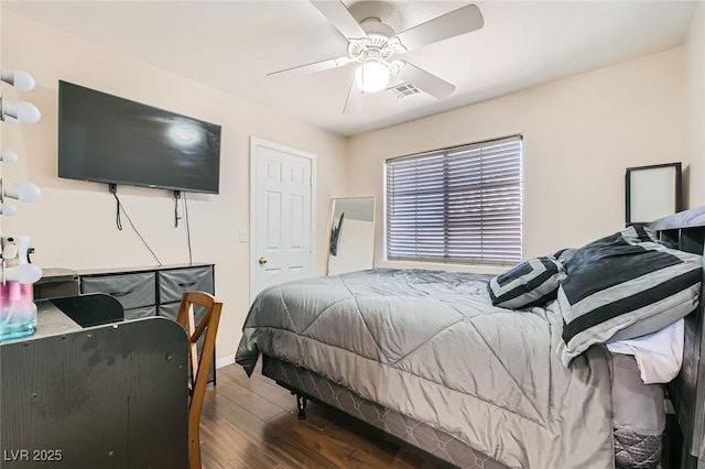 bedroom featuring wood finished floors, baseboards, and a ceiling fan