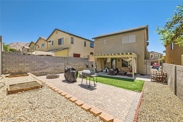 rear view of house with an outdoor living space with a fire pit, a patio area, a fenced backyard, and stucco siding