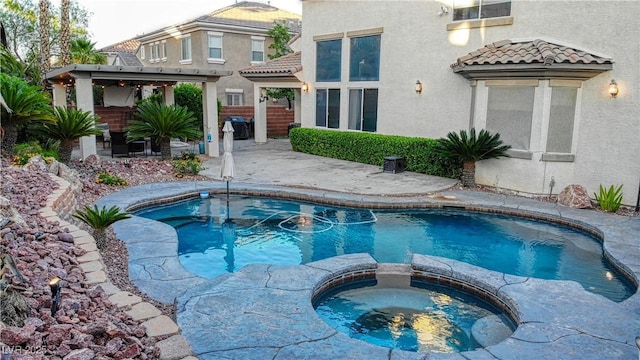 view of pool featuring a patio, a pool with connected hot tub, and a gazebo