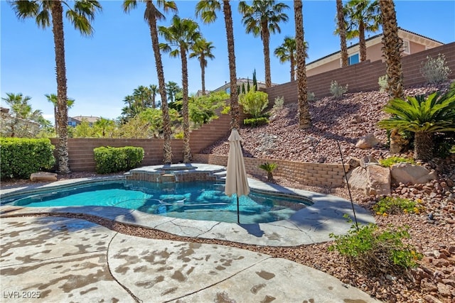 view of pool featuring a fenced backyard and a pool with connected hot tub