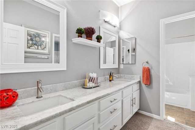 bathroom with double vanity and baseboards