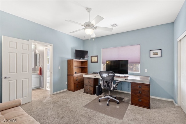 home office with light carpet, ceiling fan, and baseboards