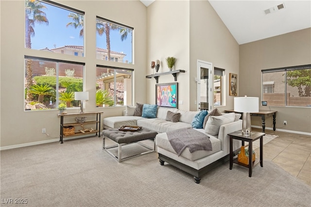 tiled living area featuring high vaulted ceiling, healthy amount of natural light, baseboards, and carpet floors