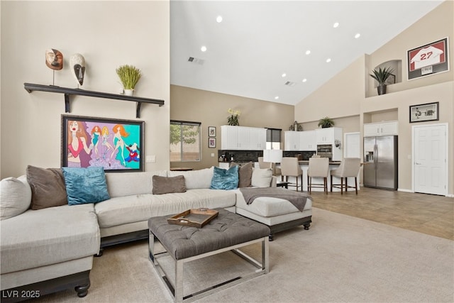 living room with high vaulted ceiling and recessed lighting