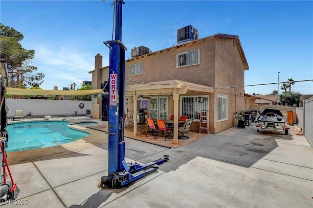 4990 Spring Oak St, Las Vegas, NV 89120 - back of house featuring fence, central AC unit, a patio area, and an outdoor hot tub