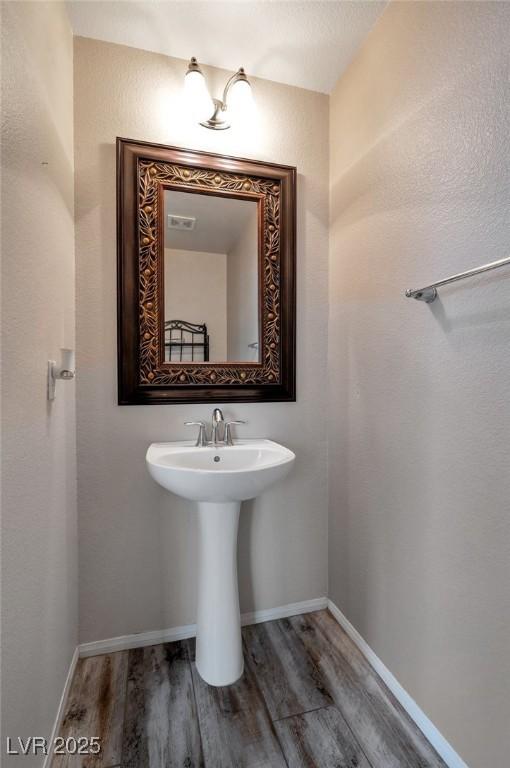 8152 Satin Carnation Ln, Las Vegas, NV 89166 - bathroom with wood finished floors, baseboards, and a sink
