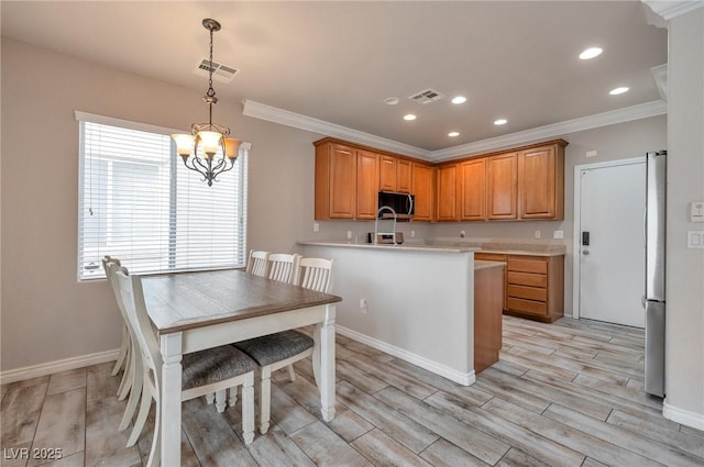 8152 Satin Carnation Ln, Las Vegas, NV 89166 - kitchen with freestanding refrigerator, crown molding, light countertops, light wood-type flooring, and a chandelier