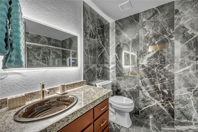 2725 S Nellis Blvd Unit 2052, Las Vegas, NV 89121 - bathroom with a marble finish shower, vanity, toilet, marble finish floors, and tile walls