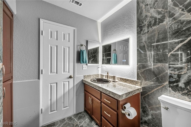 2725 S Nellis Blvd Unit 2052, Las Vegas, NV 89121 - bathroom featuring a textured wall, toilet, vanity, and marble finish floors