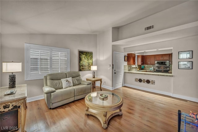 2725 S Nellis Blvd Unit 2052, Las Vegas, NV 89121 - living area featuring vaulted ceiling, light wood-style flooring, and baseboards