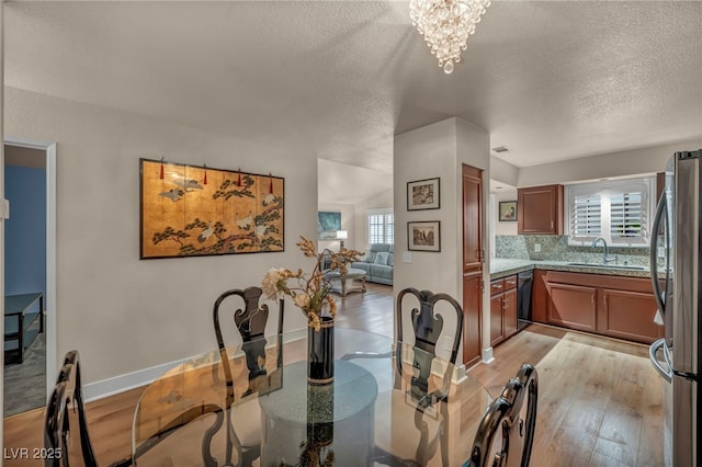 2725 S Nellis Blvd Unit 2052, Las Vegas, NV 89121 - dining area featuring a textured ceiling, light wood finished floors, a chandelier, and baseboards