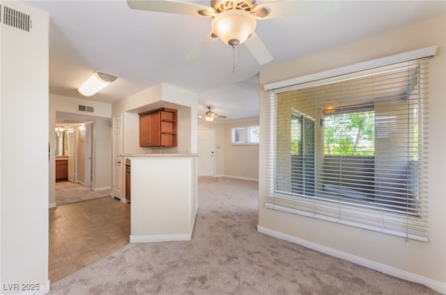 4400 S Jones Blvd Unit 2033, Las Vegas, NV 89103 - kitchen featuring open shelves, ceiling fan, brown cabinets, light colored carpet, and baseboards