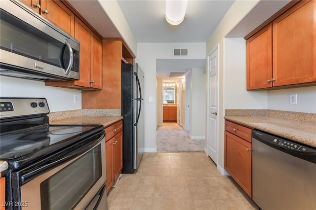 4400 S Jones Blvd Unit 2033, Las Vegas, NV 89103 - kitchen with stainless steel appliances, brown cabinetry, light countertops, and baseboards
