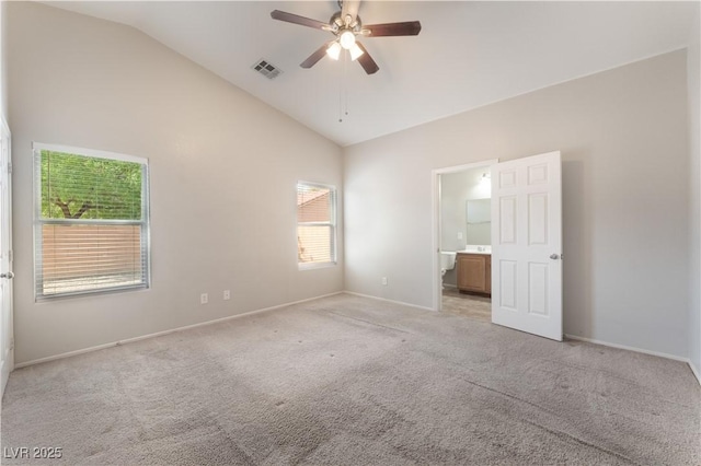 unfurnished bedroom with vaulted ceiling, light colored carpet, baseboards, ensuite bathroom, and a ceiling fan