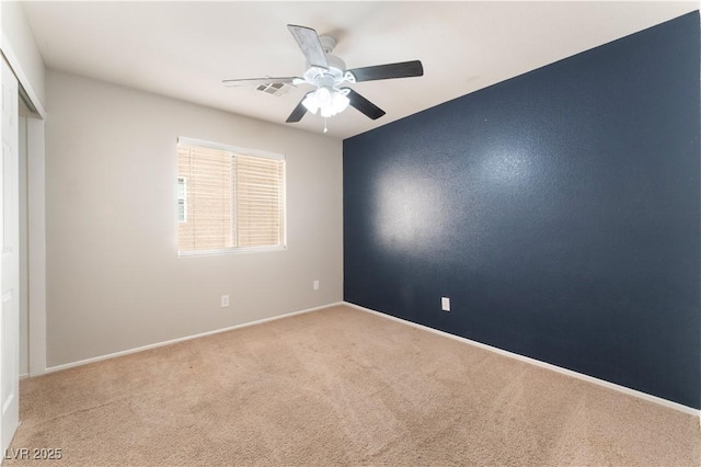 spare room with carpet flooring, a ceiling fan, and baseboards