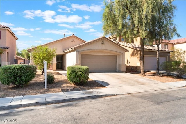 mediterranean / spanish home featuring a garage, stucco siding, concrete driveway, and a tiled roof