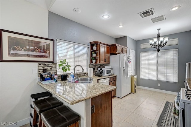 8250 Lincoln Valley St, Las Vegas, NV 89123 - kitchen featuring white appliances, a sink, a chandelier, a peninsula, and decorative backsplash