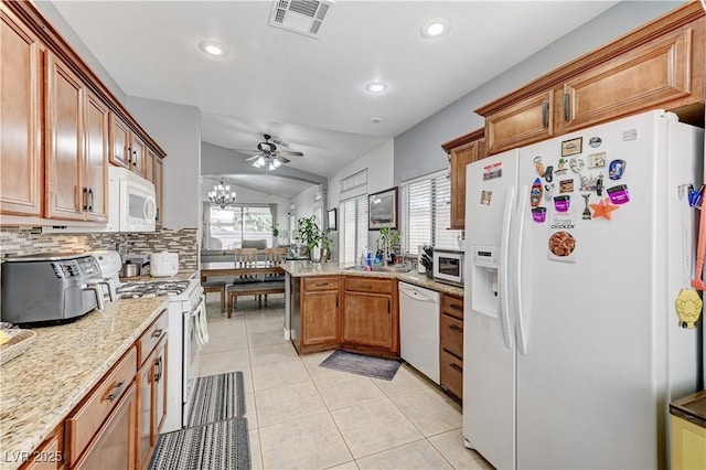 8250 Lincoln Valley St, Las Vegas, NV 89123 - kitchen featuring white appliances, a peninsula, brown cabinetry, tasteful backsplash, and lofted ceiling