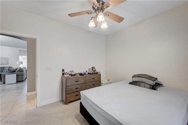 8250 Lincoln Valley St, Las Vegas, NV 89123 - bedroom with baseboards, arched walkways, a ceiling fan, light carpet, and light tile patterned floors