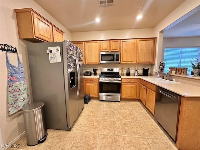 2558 Divine Sky Dr, Henderson, NV 89044 - kitchen featuring appliances with stainless steel finishes, a sink, light countertops, a peninsula, and light tile patterned flooring
