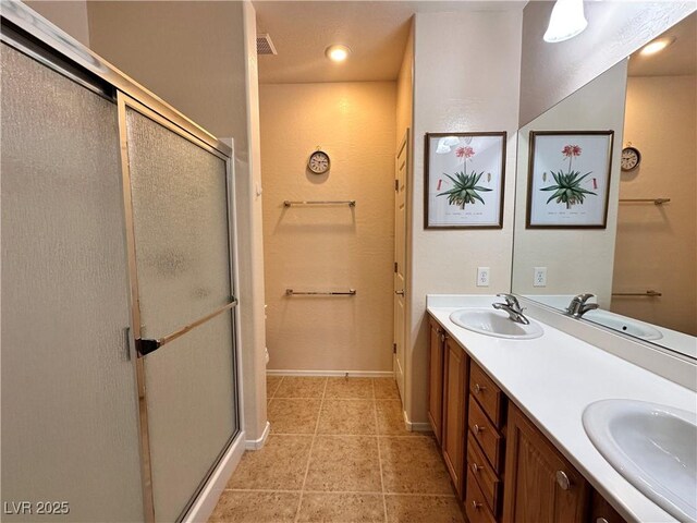 2558 Divine Sky Dr, Henderson, NV 89044 - full bathroom featuring a stall shower, double vanity, baseboards, and tile patterned floors