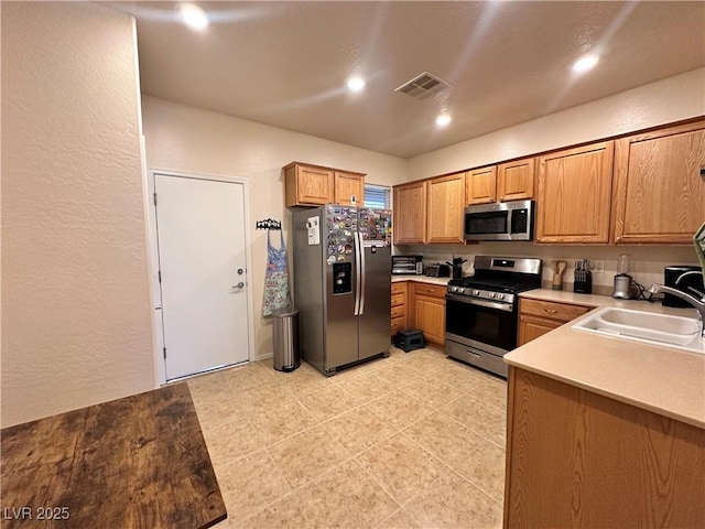 2558 Divine Sky Dr, Henderson, NV 89044 - kitchen with stainless steel appliances, a sink, a textured wall, light countertops, and recessed lighting