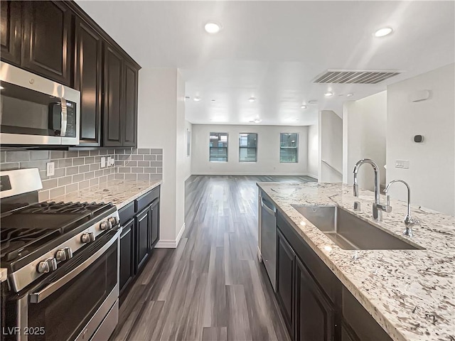 148 Campbelltown Ave, Henderson, NV 89015 - kitchen featuring stainless steel appliances, a sink, dark wood-type flooring, light stone counters, and tasteful backsplash