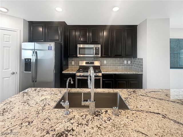 148 Campbelltown Ave, Henderson, NV 89015 - kitchen featuring stainless steel appliances, dark cabinetry, light stone counters, and recessed lighting