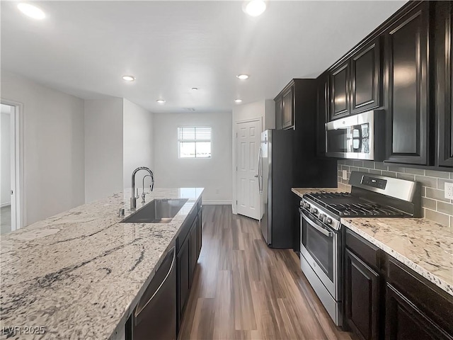 148 Campbelltown Ave, Henderson, NV 89015 - kitchen featuring stainless steel appliances, a sink, dark wood-style flooring, light stone counters, and backsplash