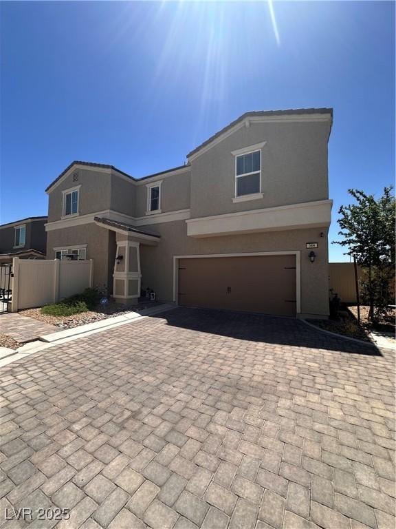 369 Stone Fly Rd, North Las Vegas, NV 89032 - view of front of house featuring an attached garage, stucco siding, decorative driveway, and fence