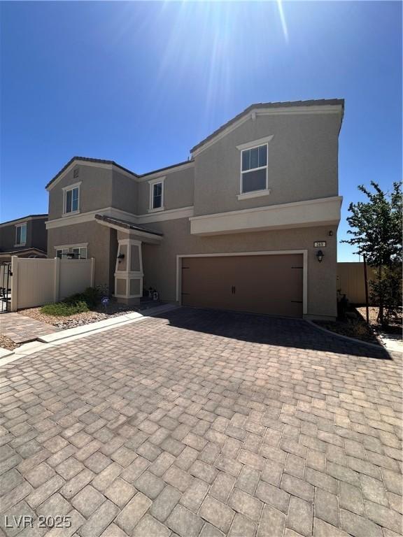 369 Stone Fly Rd, North Las Vegas, NV 89032 - view of front facade featuring a garage, decorative driveway, stucco siding, and fence