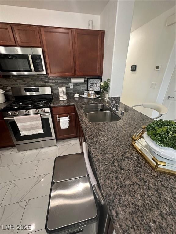 369 Stone Fly Rd, North Las Vegas, NV 89032 - kitchen featuring stainless steel appliances, a sink, light marble finish floors, dark stone countertops, and a peninsula
