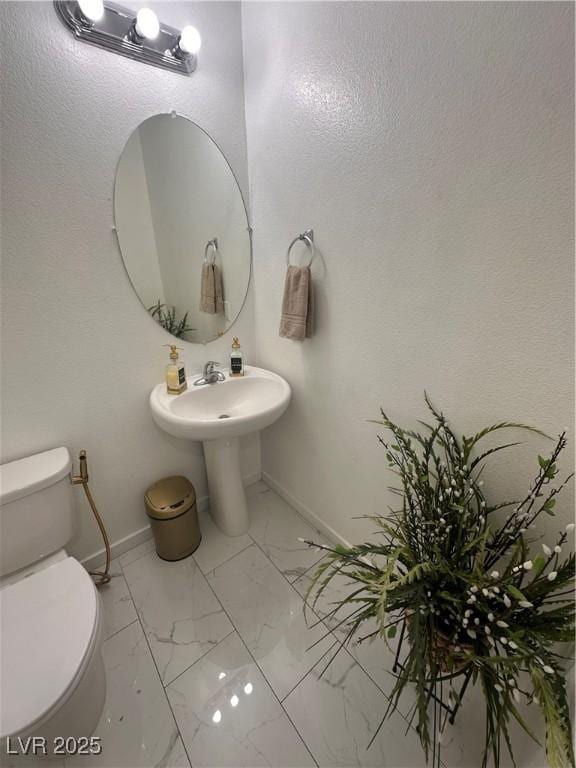 369 Stone Fly Rd, North Las Vegas, NV 89032 - bathroom with marble look tiles, toilet, and baseboards